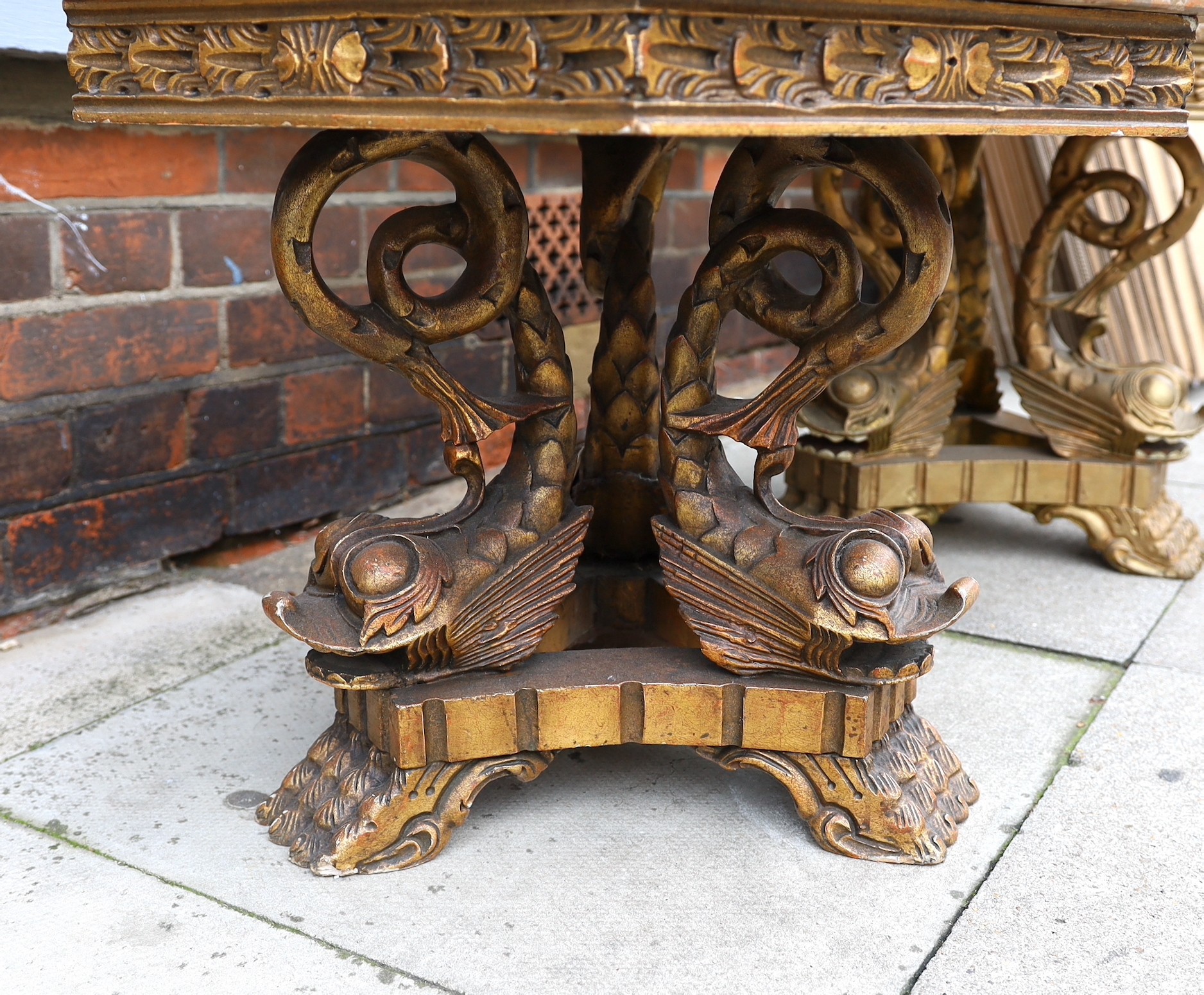 A near pair of 1960’s Italian carved giltwood occasional tables, with hexagonal marble tops and stylised dolphin underframes, height 48cm. width 66cm